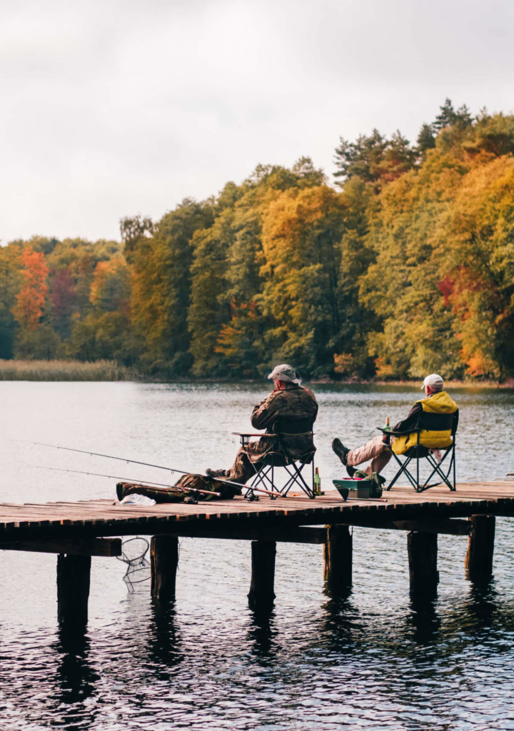 Men fishing from dock with autumn foliage